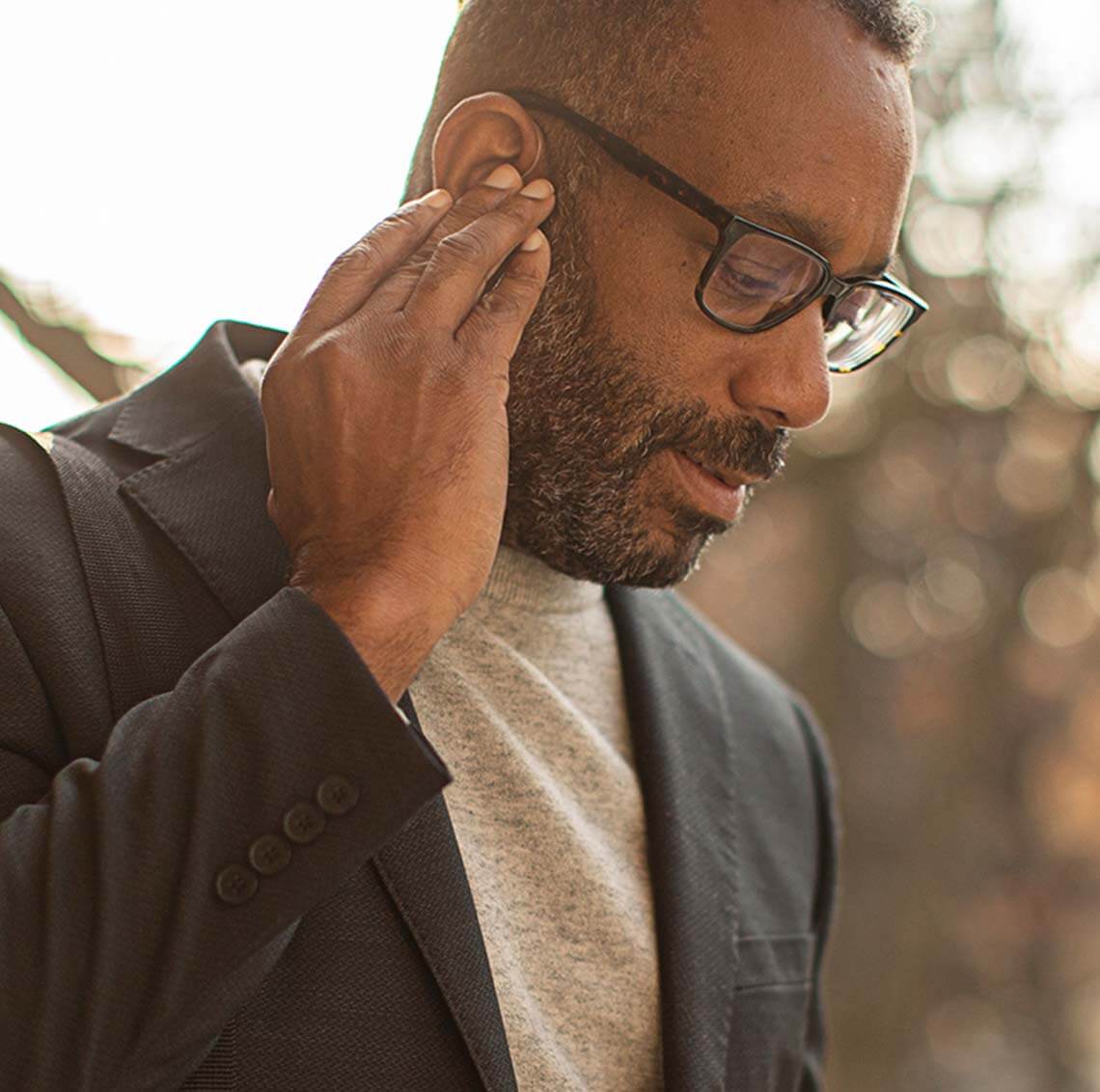 Man Tapping his Hearing Aids