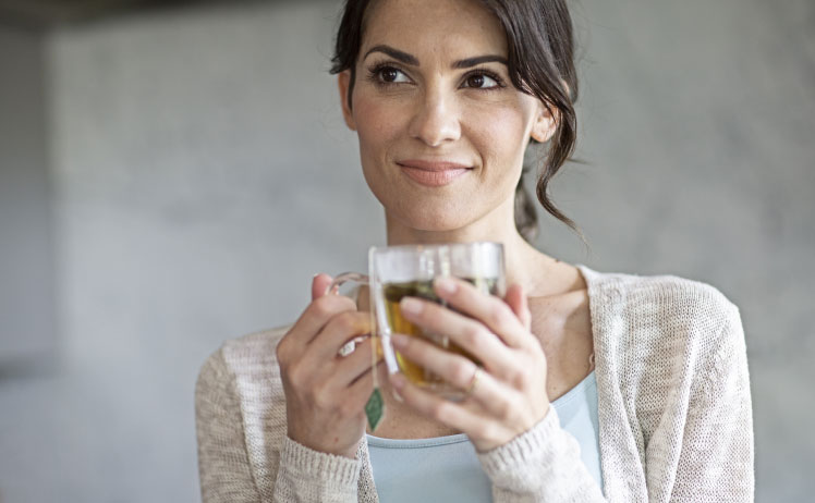 Person holding a cup of coffee thinking about Starkey Hearing Aids