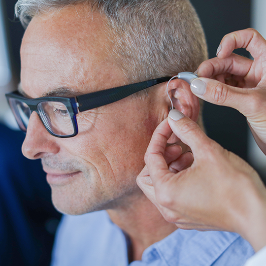 Man being fit with a RIC hearing aid.