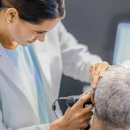 An Audiologist inspecting a patient's ear